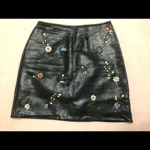 Leather miniskirt with enamel flowers
